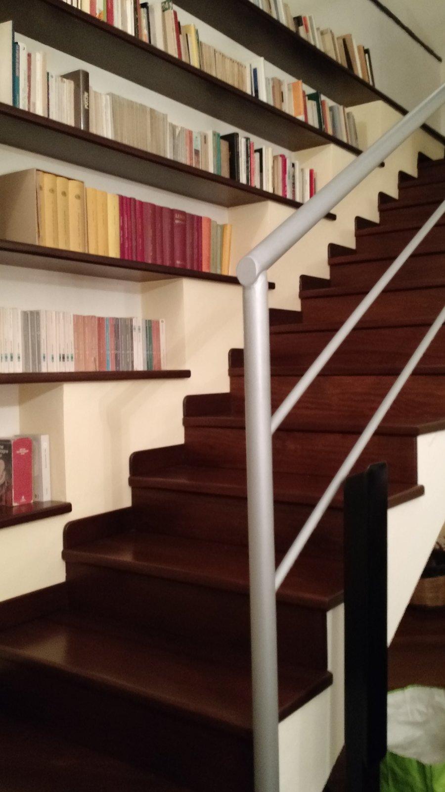Book case and stairs to the left of the entrance to the living room.