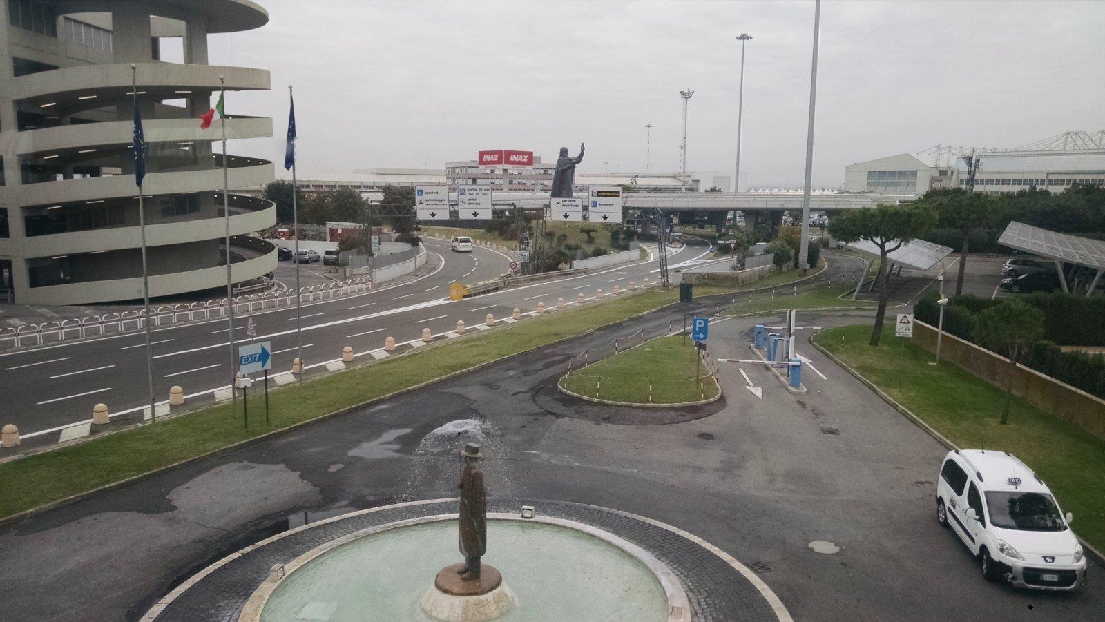 The Leonardo Da Vinci Statue at the airport could be seen with his upraised arm slightly in the distance. 