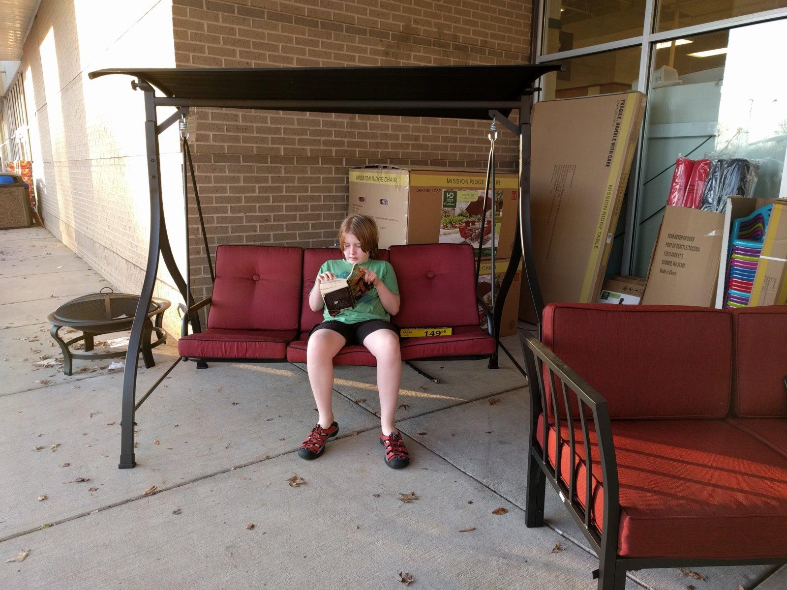Getting a couple hours of reading in while waiting for his sisters.